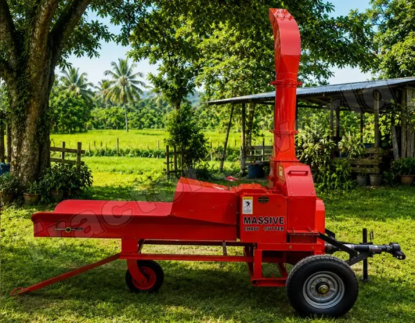 Red portable chaff cutter on a farm trailer, with a tall vertical intake/exhaust and the label 'Massive Chaff Cutter' beside a green yard and shed in the background